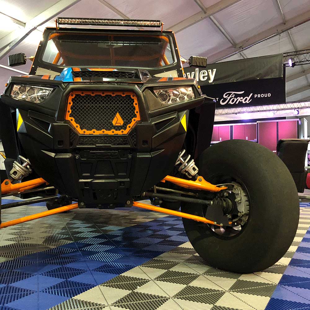 UTV parked on top of Ribtrax Pro garage flooring tiles at a tradeshow